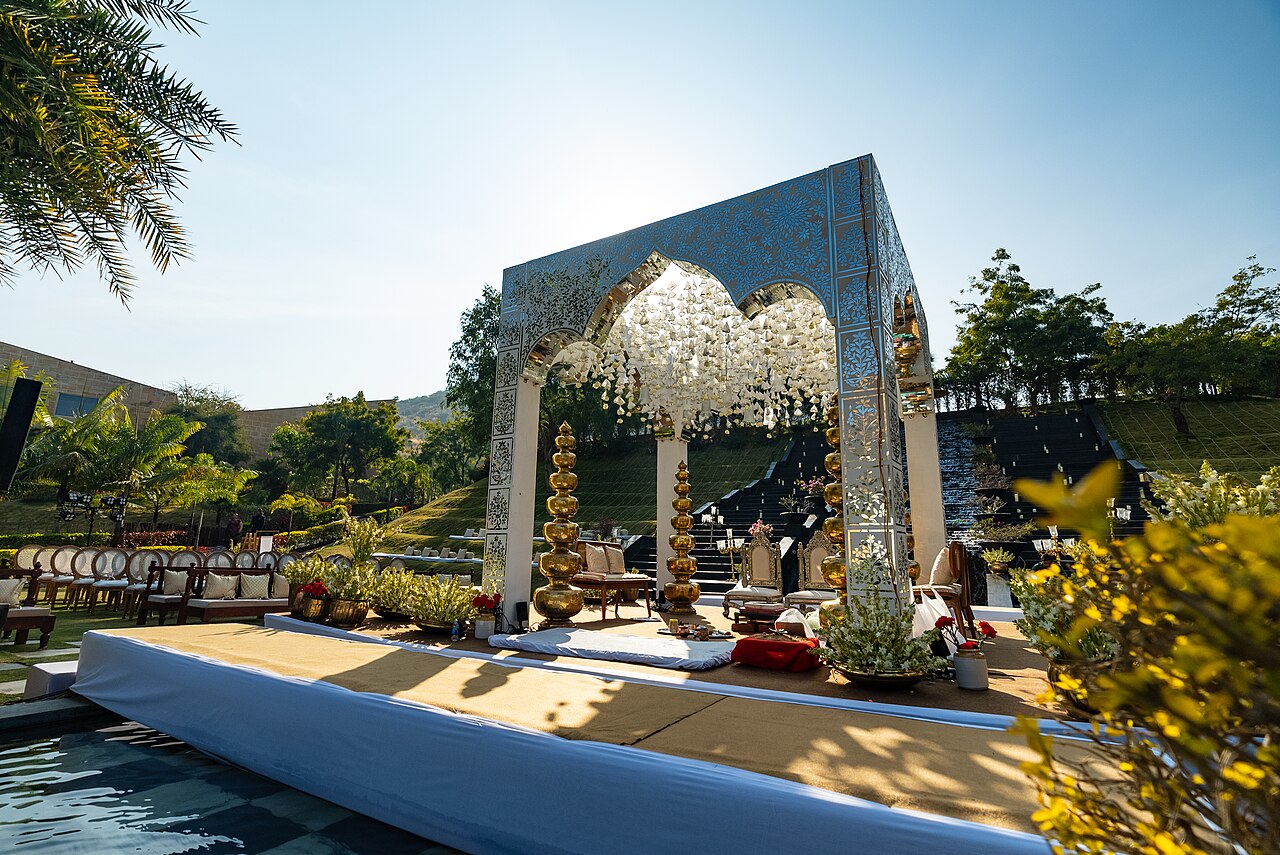 Outdoor wedding mandap with mirrored panels and a white floral canopy