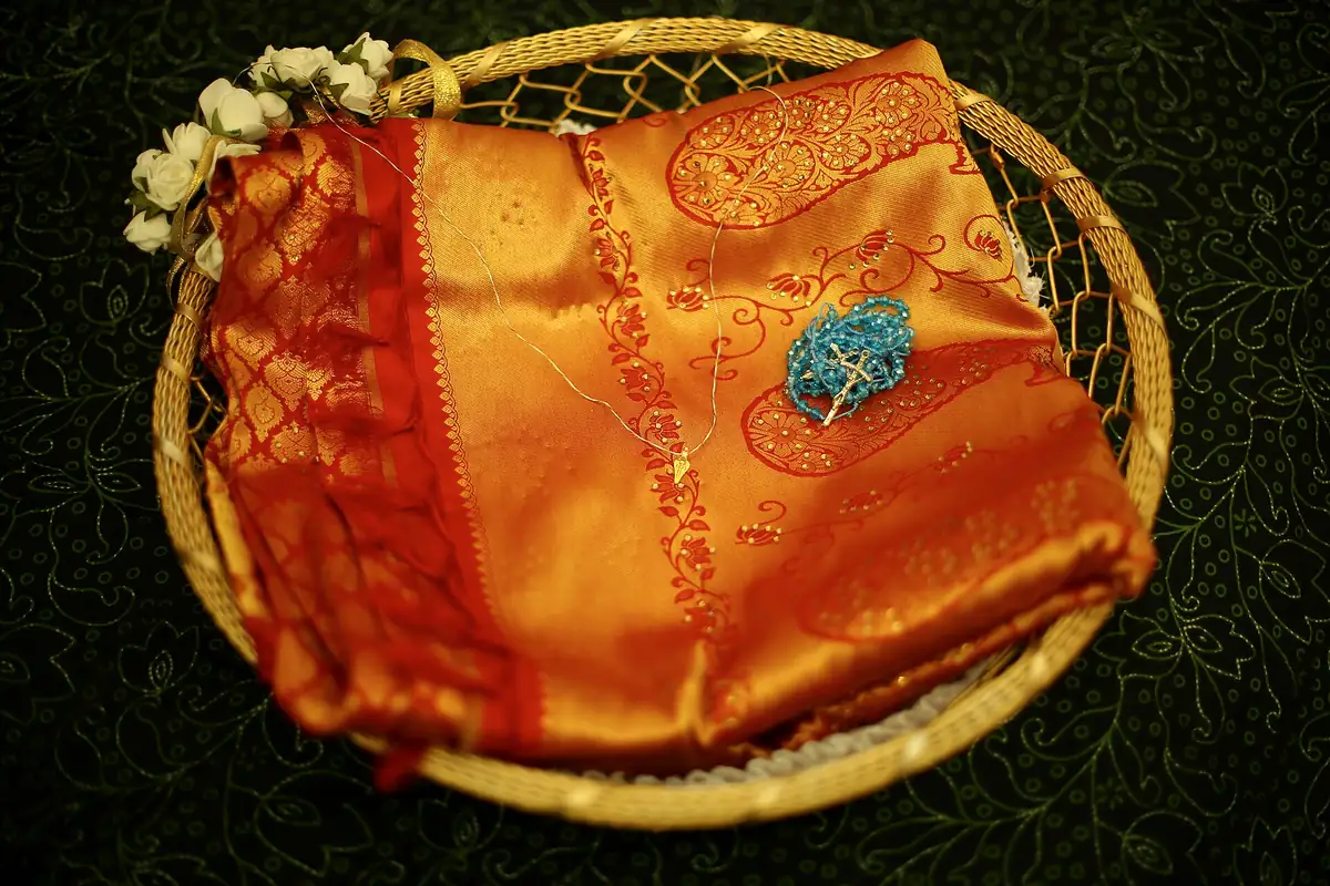 A manthrakodi saree with a rosary and minnu in a basket, ready for a Kerala Christian wedding
