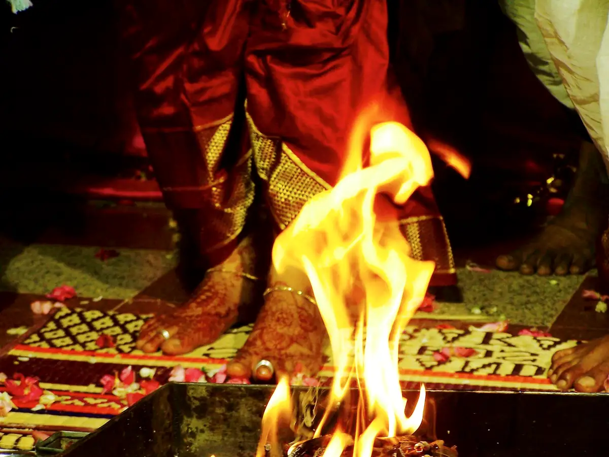 Feet with toe rings stepping beside the sacred fire during saptapadi